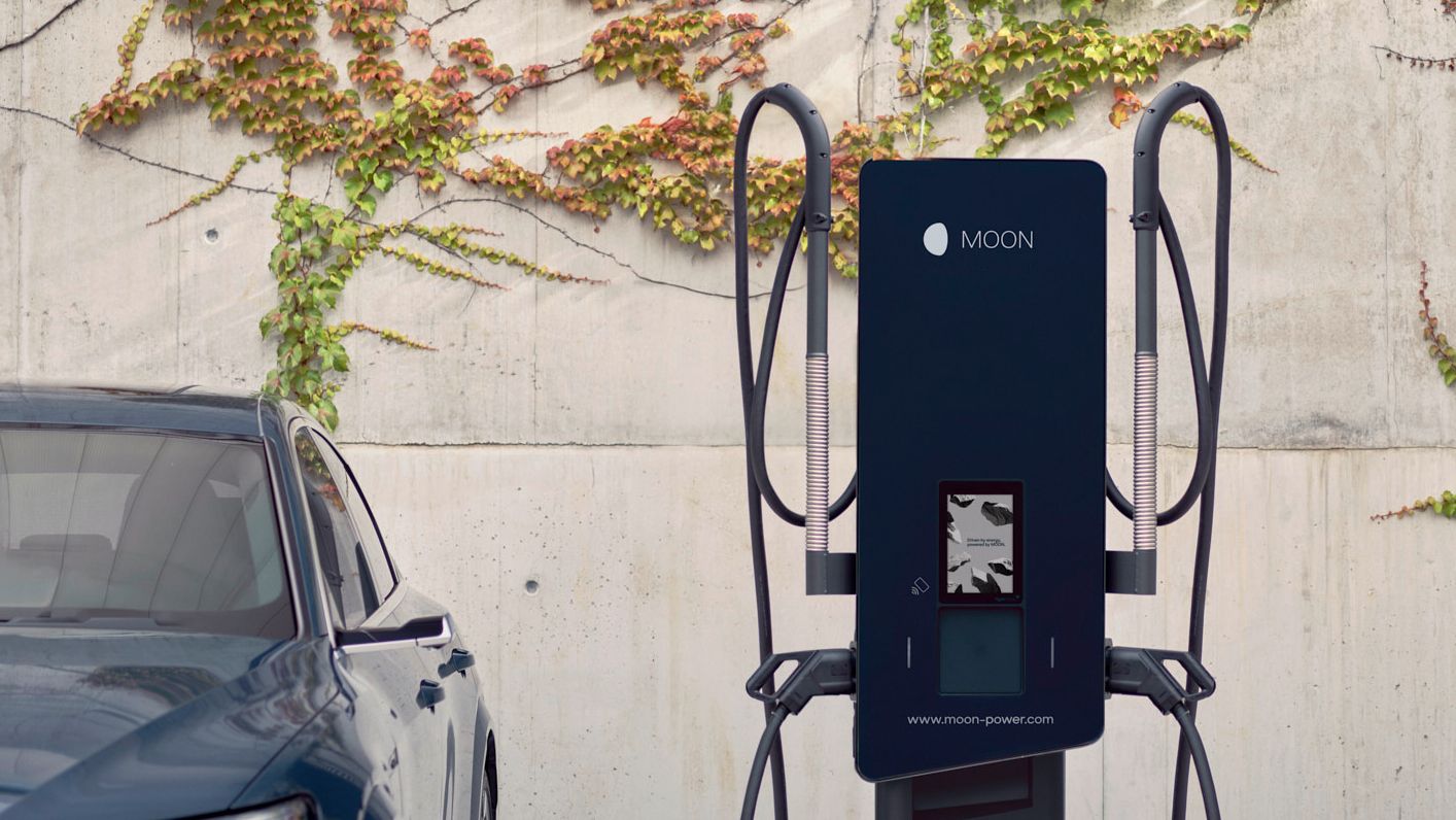 Električni avtomobil parkiran ob MOON polnilnici.