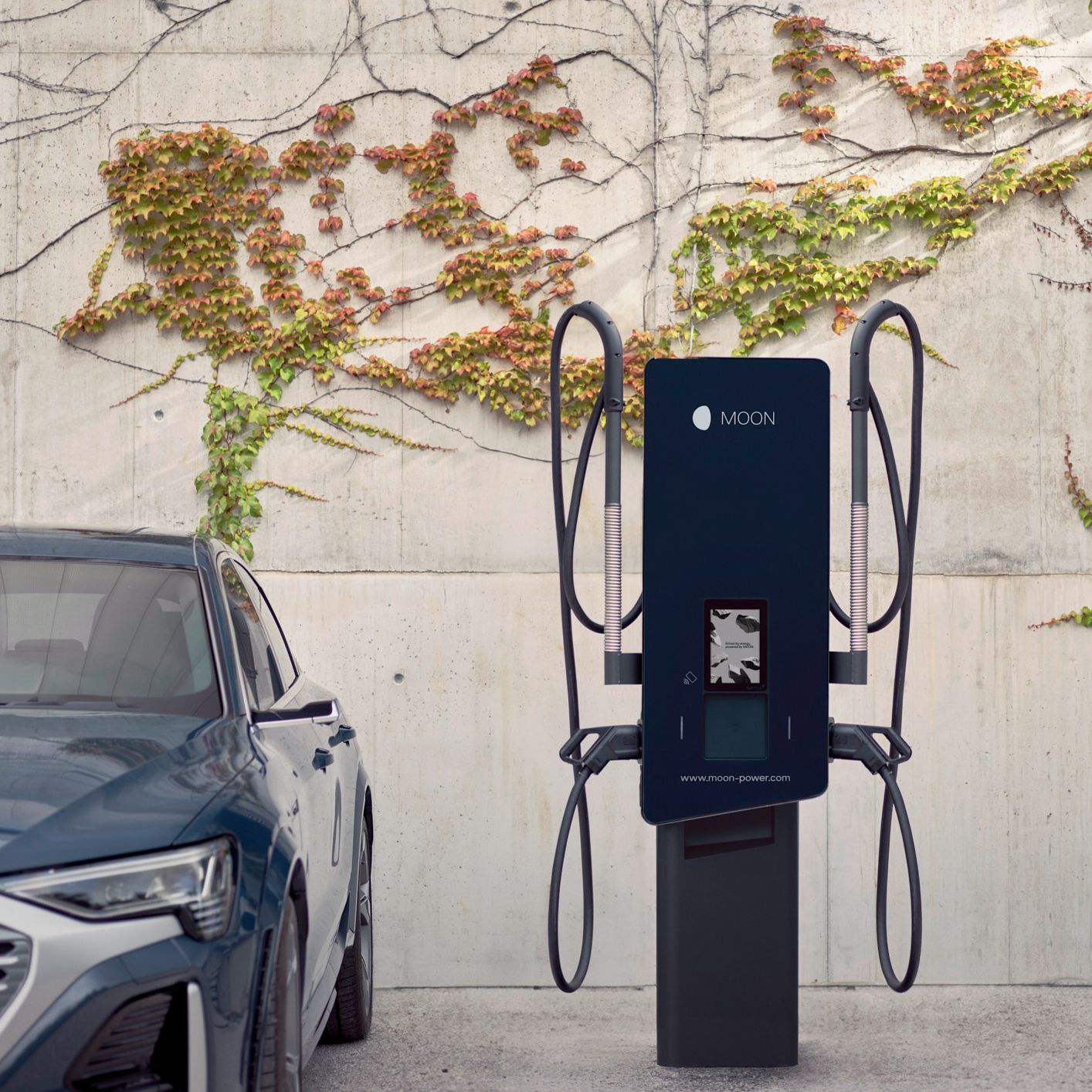 Električni avtomobil parkiran ob MOON polnilnici.