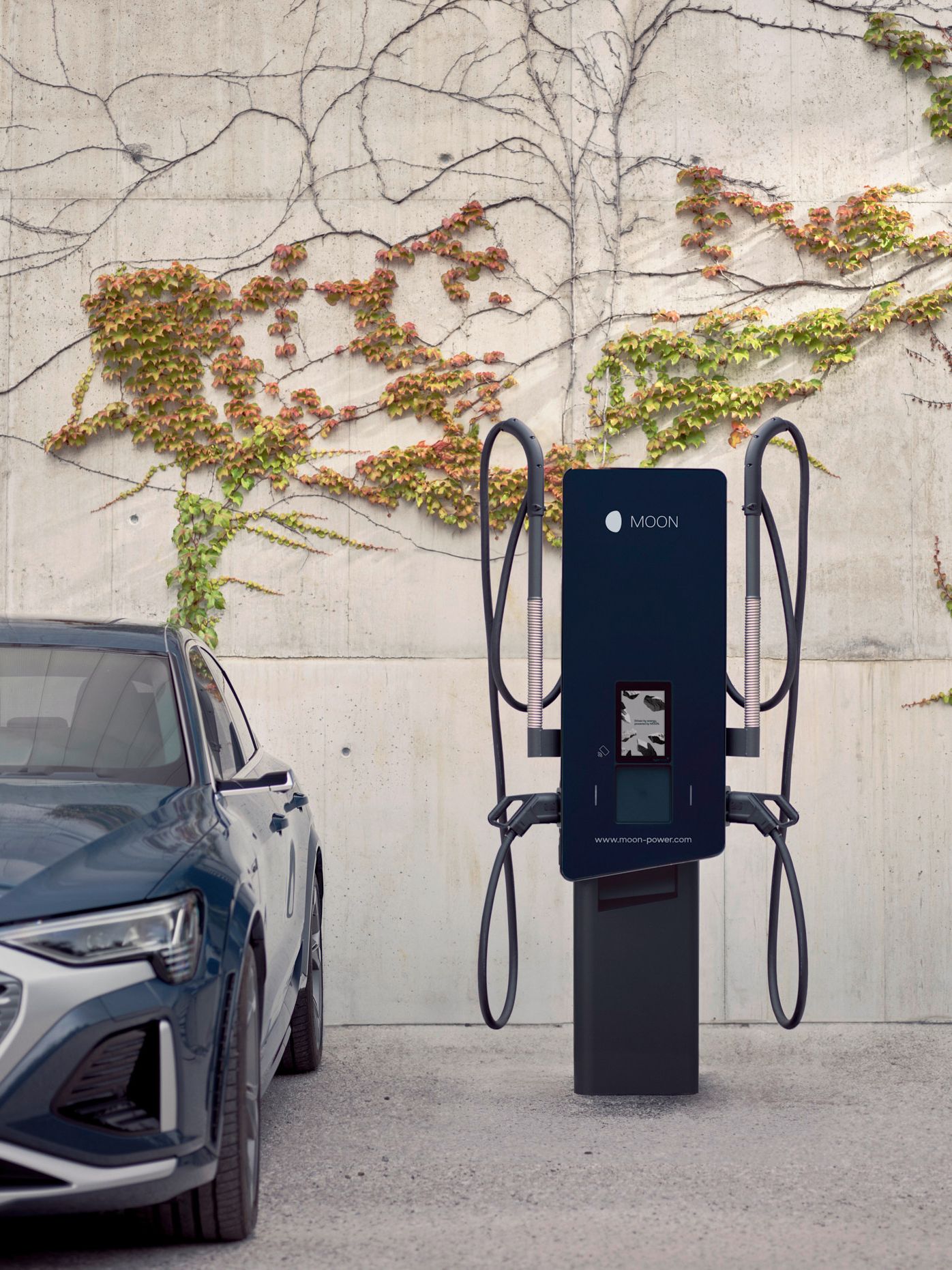 Električni avtomobil parkiran ob MOON polnilnici.