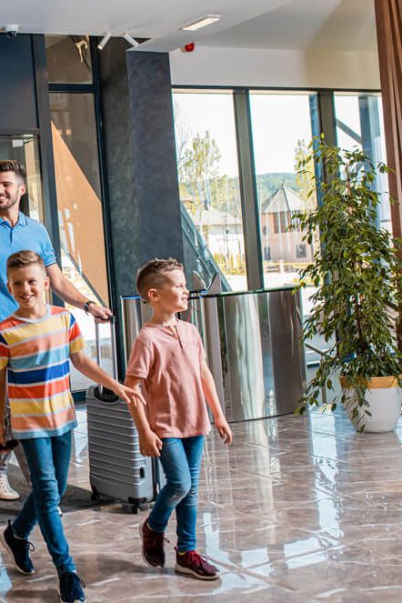 Družina z dvema otrokoma prihaja v hotel.
