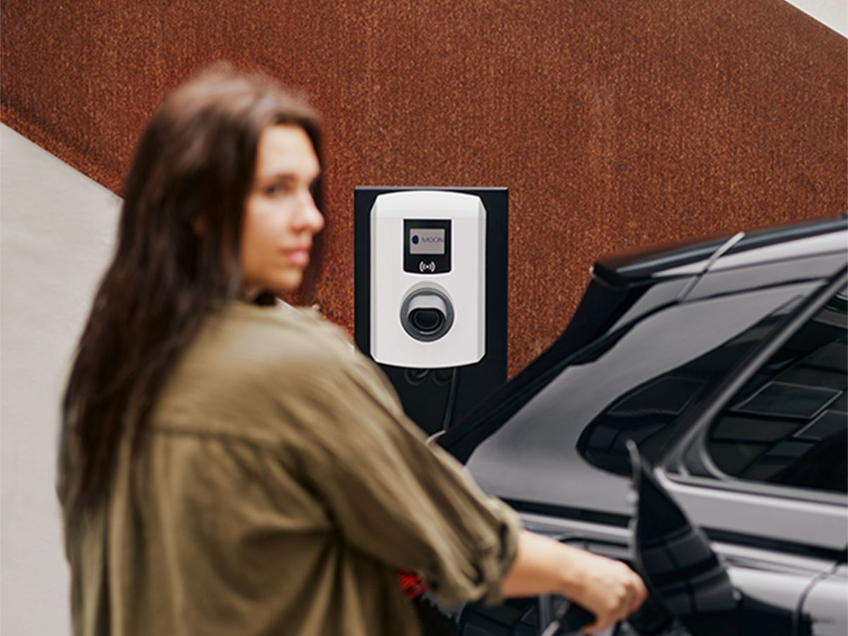 Ženska polni električni avto s stensko polnilno postajo