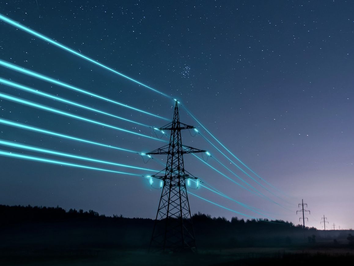 Daljnovod z osvetljenimi kabli, ki ponazarjajo pretok električne energije.