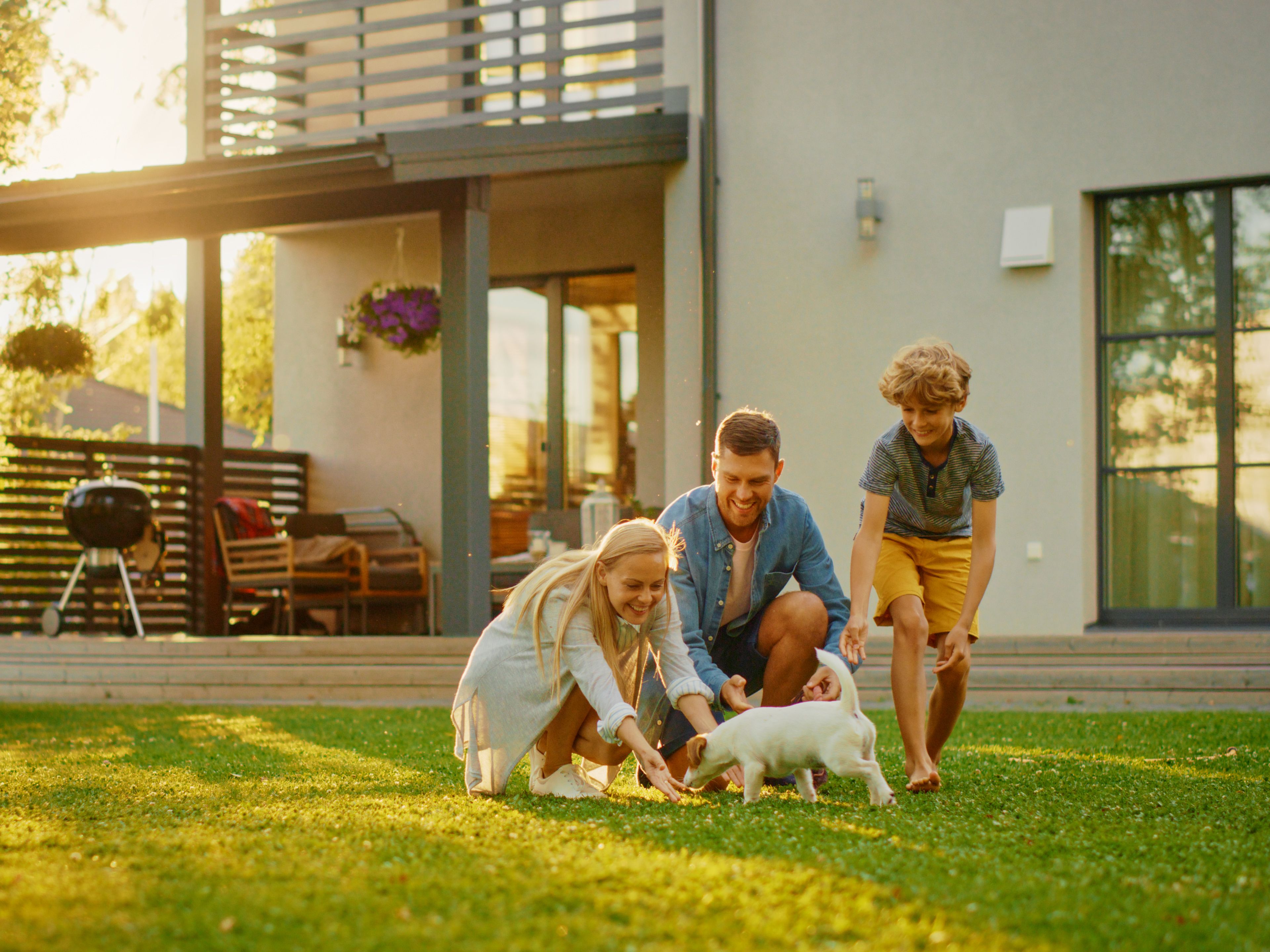 Družina se igra s psom na vrtu.